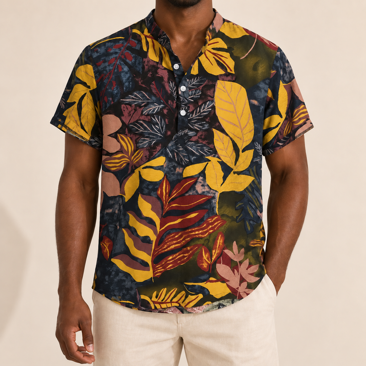 Model wearing a dark short-sleeve shirt with yellow, burgundy and pink leaves