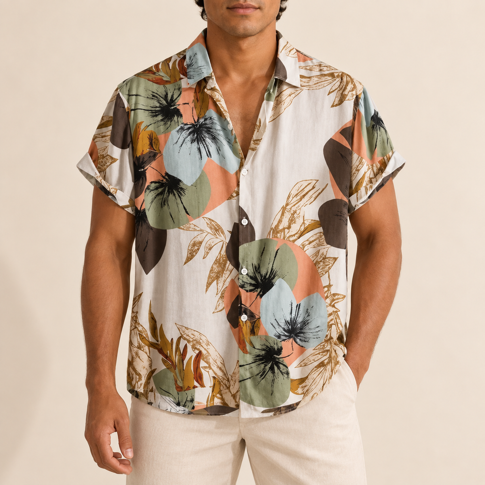 Model wearing a cream short-sleeve shirt with muted green and peach botanical shapes