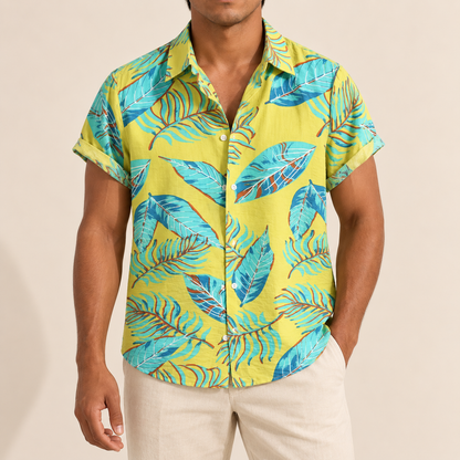 Model wearing a yellow short-sleeve shirt with turquoise outlined leaves