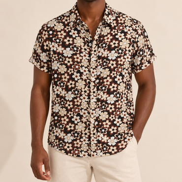 Model wearing a dark short-sleeve shirt with cream and brown flowers