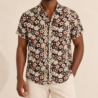 Model wearing a dark short-sleeve shirt with cream and brown flowers