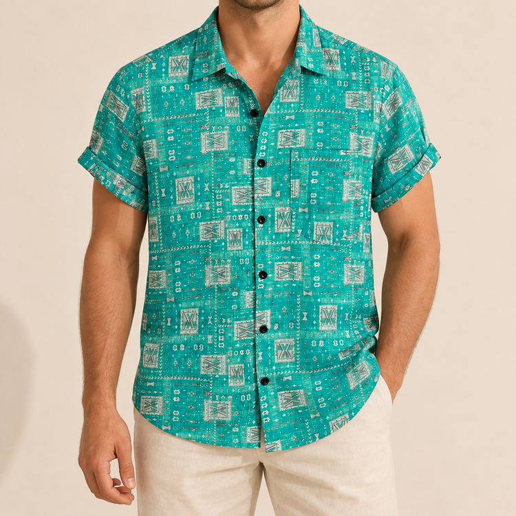 Model wearing a turquoise button-up shirt with small pale geometric tiles and a chest pocket