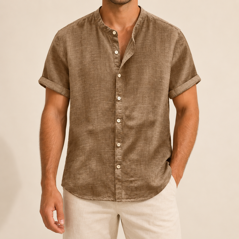 Model wearing a tan short-sleeve band-collar shirt with buttons down to the hem