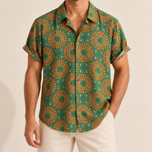 Model wearing green short-sleeve button-up shirt with yellow and orange sunburst motifs
