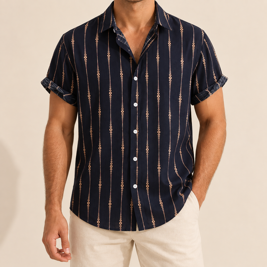 Model wearing a navy camp shirt with vertical tan and pink dotted lines